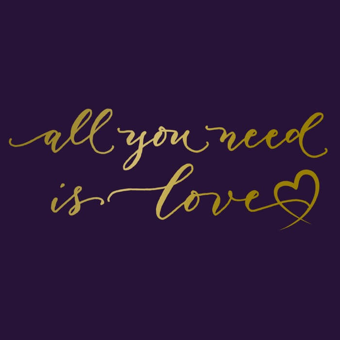 "gold all you need is love scripted font with a graphic heart on the front of a team purple image"